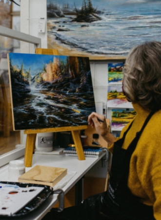 Artist painting a forest and stream image